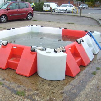 Flood barrier system using 0.5m corner multi-hub units to contain water in parking area